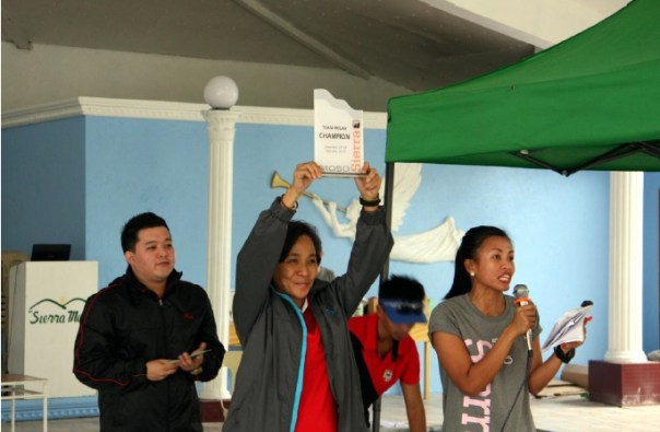 Abet Ocampo, president of Rundezvous, Inc. presents the Champion trophy for Team Relay